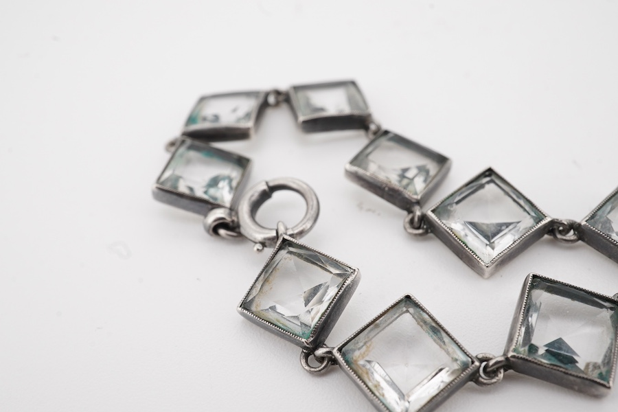 An Arts & Crafts white metal and paste cluster set circular pendant, diameter 33mm, hung from an associated white metal and quartz set necklace, 37cm.
